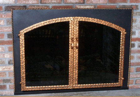 The Hyannisport Square to Arch Black frame with antique copper twisted molding, scrolled steel twin doors, with standard forged center handles,  smoke glass. Comes with slide mesh spark screen.